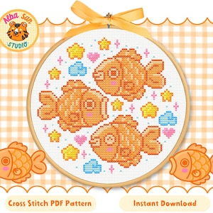 Puede incluir: Patrón de punto de cruz con tres peces naranjas sonrientes, rodeados de estrellas, corazones y nubes. El diseño está en un bastidor de bordado de madera con una cinta amarilla. El texto dice "Cross Stitch PDF Pattern" y "Instant Download".