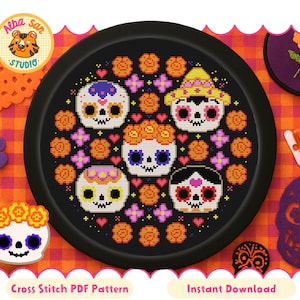 Könnte beinhalten: Ein schwarzes Tablett mit einem Kreuzstichmuster von fünf Zuckerschädeln, verziert mit Blumen und Herzen. Die Totenköpfe sind von orangefarbenen Blumen und lila Herzen umgeben. Der Text lautet "Cross Stitch PDF Pattern" und "Instant Download".