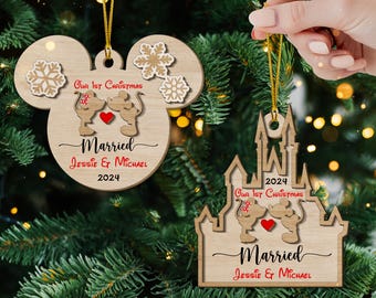 May include: Two wooden Christmas ornaments featuring a cartoon couple of mice kissing. The first ornament is shaped like Mickey Mouse's head with snowflakes and the text "Our 1st Christmas Married Jessie & Michael 2024". The second ornament is shaped like a castle with the text "2024 Our 1st Christmas Married Jessie & Michael".