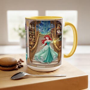 Pu&ograve; includere: Tazza in ceramica bianca con interno e manico gialli. La tazza presenta un'illustrazione colorata di una principessa in abito verde acqua, con una lanterna, su una scala. Lo sfondo include un'ambientazione di biblioteca con orologi e scaffali.