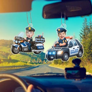 May include: Two car air fresheners with a police theme. One shows a child on a motorcycle with the name "Henry" and the text "Driver Safe Daddy!". The other features a child in a police car with the name "David" and the text "Drive Safe DADDY".