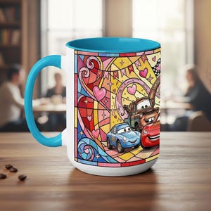 Puede incluir: Taza de cer&aacute;mica blanca con interior y asa azules. La taza presenta un colorido dise&ntilde;o de vidriera con coches de dibujos animados, corazones y estrellas. Los coches est&aacute;n en primer plano, con un fondo rosa, amarillo y azul.