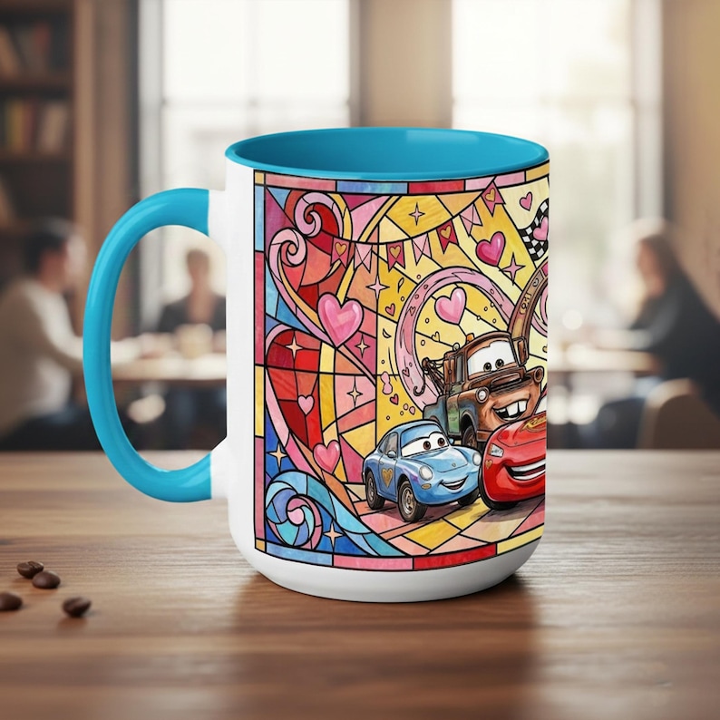 Puede incluir: Taza de cer&aacute;mica blanca con interior y asa azules. La taza presenta un colorido dise&ntilde;o de vidriera con coches de dibujos animados, corazones y estrellas. Los coches est&aacute;n en primer plano, con un fondo rosa, amarillo y azul.