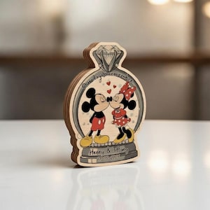 May include: Wooden wedding keepsake featuring Mickey and Minnie Mouse kissing inside a diamond ring design. The ring has the text "Our day to remember" and the names "Henry & Tiffany" with a date. The characters are in their classic outfits.