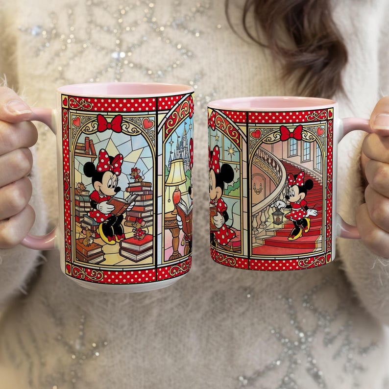 Puede incluir: Dos tazas de cer&aacute;mica con interiores y asas rosas. Cada taza presenta un dise&ntilde;o de estilo vidriera con Minnie Mouse con un vestido de lunares rojos. Una taza muestra a Minnie leyendo, la otra la muestra subiendo escaleras. Las tazas tienen un borde rojo punteado.