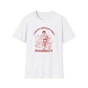 May include: White t-shirt with a red graphic of a group of people in McDonald's costumes. The text reads "I had my birthday party at McDonald's".