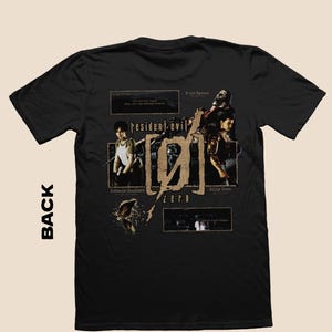 May include: Black t-shirt featuring a graphic design from the video game Resident Evil Zero. The design includes the game's logo, character images, and text elements. The back of the shirt is visible.
