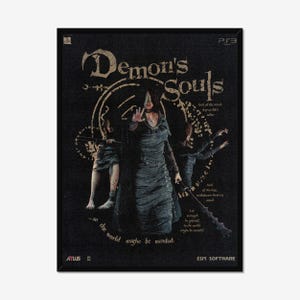 May include: A black art print featuring the game title "Demon's Souls." The artwork depicts a robed figure with outstretched hand, and two other figures. Text includes "Soul of the mind, key to life's tales" and "...so the world might be mended."