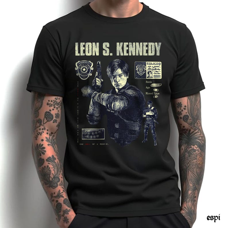 May include: Black t-shirt featuring a graphic of Leon S. Kennedy holding a gun, with text that reads "LEON S. KENNEDY." The design includes police badges and a character ID card. The shirt is a crew neck.