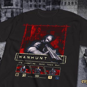 Op de afbeelding: Zwart T-shirt met een afbeelding uit het videospel "Manhunt". Het ontwerp toont een figuur met een shotgun tegen een rode en grijze stedelijke achtergrond. Tekst luidt "It's Showtime. Make them pay."