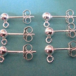 May include: Six silver earring findings with a round ball at the top and a loop on the bottom. The findings have a post with a butterfly back.