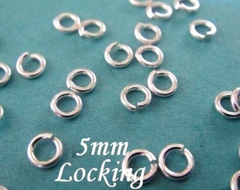 May include: A close-up of a group of silver 5mm locking jump rings on a turquoise surface. The rings are small and round, with a gap in the circle. The text "5mm Locking" is visible in the image.