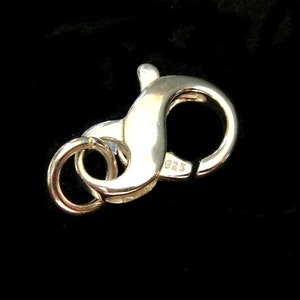 May include: Silver lobster clasp with a 925 stamp. The clasp is a popular choice for necklaces and bracelets.