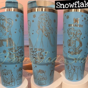 Puede incluir: Tres vasos de acero inoxidable azules con un dise&ntilde;o de copo de nieve y detalles de purpurina dorada. Los vasos presentan una cita que dice "Algunas personas valen la pena derretirse por ellas". Los vasos est&aacute;n decorados con im&aacute;genes de personajes de la pel&iacute;cula Frozen.