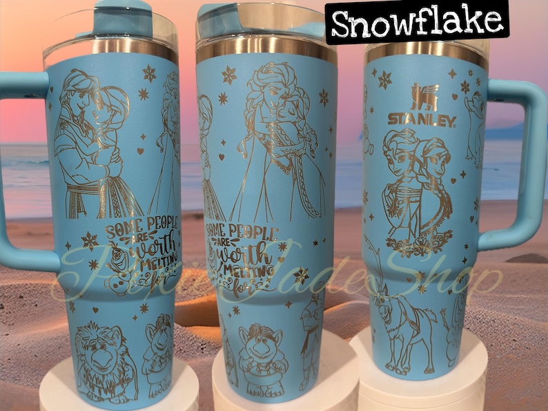 Puede incluir: Tres vasos de acero inoxidable azules con un dise&ntilde;o de copo de nieve y detalles de purpurina dorada. Los vasos presentan una cita que dice "Algunas personas valen la pena derretirse por ellas". Los vasos est&aacute;n decorados con im&aacute;genes de personajes de la pel&iacute;cula Frozen.