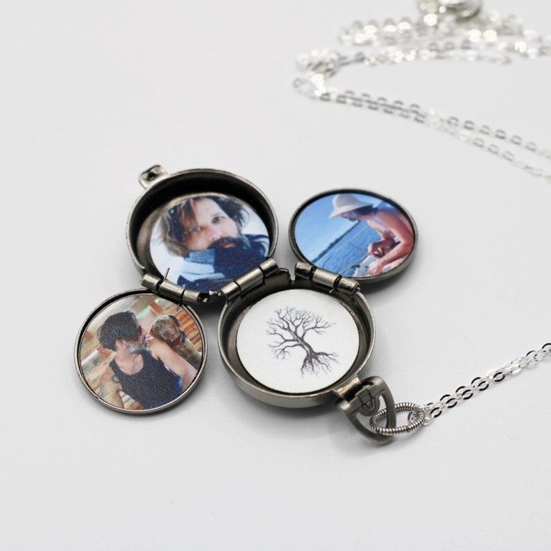 Peut inclure: Un collier avec un m&eacute;daillon argent&eacute; &agrave; quatre compartiments circulaires, chacun r&eacute;v&eacute;lant une image diff&eacute;rente. Le m&eacute;daillon est ouvert, affichant des photos de personnes et une illustration d'arbre. La cha&icirc;ne du collier est &eacute;galement argent&eacute;e.