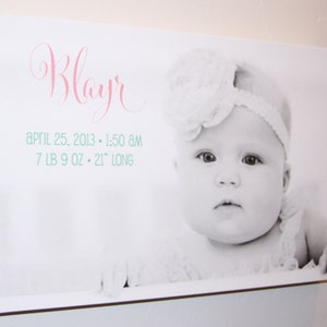 May include: A black and white photo of a baby girl named "Blayr" wearing a white headband and a white flower. The photo is printed on a white canvas with the text "April 25, 2013 - 1:50 AM 7 LB 9 OZ - 21" LONG" printed below the photo.
