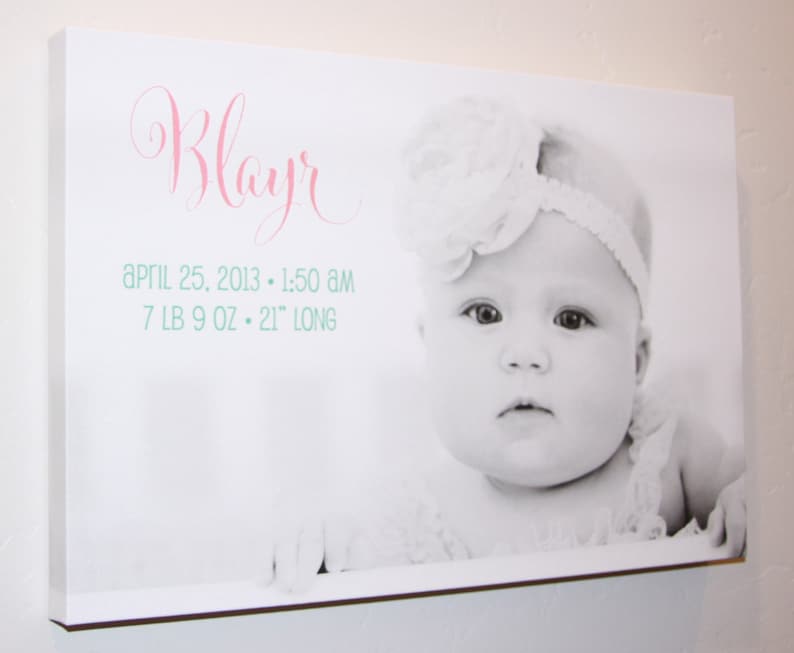 May include: A black and white photo of a baby girl named "Blayr" wearing a white headband and a white flower. The photo is printed on a white canvas with the text "April 25, 2013 - 1:50 AM 7 LB 9 OZ - 21" LONG" printed below the photo.