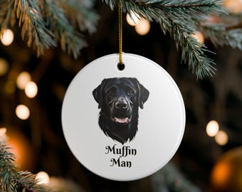 Könnte beinhalten: Runder, weißer Weihnachtsschmuck mit dem Porträt eines schwarzen Labrador Retrievers. Der Text "Muffin Man" ist unter dem Bild des Hundes aufgedruckt. Der Anhänger hängt an einem goldenen Faden.