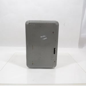 May include: A rectangular, gray metal Intermatic box with a rounded top and a small black slot on the right side. The box has some wear and tear, with a few white marks on the front.
