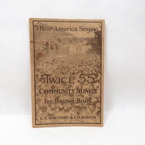 May include: A vintage brown book cover with the title "I Hear America Singing" and "Twice 55 Community Songs The Brown Book." The cover features an illustration of a crowd and a bandstand. Published by C.C. Birchard & Co. Boston.