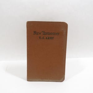 May include: A brown leather-bound book with the text "New Testament U.S. Army" printed on the front cover.