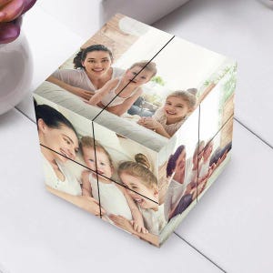 Op de afbeelding: Een gepersonaliseerde fotokubus met familieportretten. De kubus toont meerdere afbeeldingen van een moeder en haar kinderen, die gelukkige momenten vastleggen. De kubus is een uniek cadeau-idee, perfect voor het tonen van dierbare herinneringen.