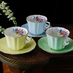 Taza y platillo antiguos de porcelana Grafton, color pastel acanalado, en amarillo, verde menta o azul claro, con interior decorado con un ramo de rosas y ribete dorado. Inglaterra, década de 1940.
