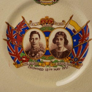 Puede incluir: Un plato conmemorativo de cer&aacute;mica con retratos en tono sepia del rey Jorge VI y la reina Isabel en marcos ovalados. El dise&ntilde;o incluye banderas cruzadas, una corona, el texto DIEU ET MON DROIT y H.M. KING GEORGE VI. H.M. QUEEN ELIZABETH CROWNED 12TH MAY 1937.
