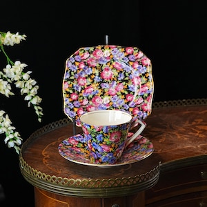 Juego de tres tazas de té vintage Royal Winton “Majestic” Chintz – Grimwades England. Plato lateral cuadrado negro con estampado floral y borde dorado, década de 1930.