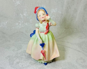 Figura vintage de Royal Doulton "Bebé" HN1679 – Niña de porcelana fina pintada a mano con sombrilla, diseñada por Leslie Harradine, Inglaterra, década de 1930.