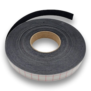 Könnte beinhalten: Eine Rolle schwarzes Dichtungsband. Das Band ist mit einem Pappkern aufgerollt. Die Rückseite des Bandes hat ein weißes und rotes Gittermuster. Eine Länge des Bandes ist abgerollt.