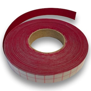 Può includere: Un rotolo di nastro per bordi rosso con un motivo a griglia sul lato adesivo. Il nastro è avvolto attorno a un'anima di cartone e una porzione del nastro è srotolata, mostrando la sua flessibilità. Il colore rosso è uniforme.