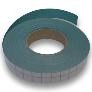 Op de afbeelding: Een rol tealkleurige tape met een witte, rasterpatroon zelfklevende achterkant. De tape is opgerold rond een kartonnen kern, met een deel afgerold, waardoor de lijm zichtbaar is. De tape is waarschijnlijk voor knutselen of algemeen gebruik.