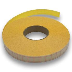Könnte beinhalten: Eine Rolle gelbes doppelseitiges Klebeband mit einem roten Gittermuster auf der Klebeseite. Das Band ist um einen Pappkern gewickelt, wobei ein Teil abgerollt und nach oben gebogen ist. Das Band ist für verschiedene Bastel- und Verpackungsanwendungen konzipiert.