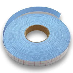 Può includere: Un rotolo di nastro di tessuto azzurro con retro autoadesivo. Il nastro è avvolto attorno a un'anima di cartone. Il retro ha un motivo a griglia di linee rosse. Il nastro è largo circa 2,5 cm.