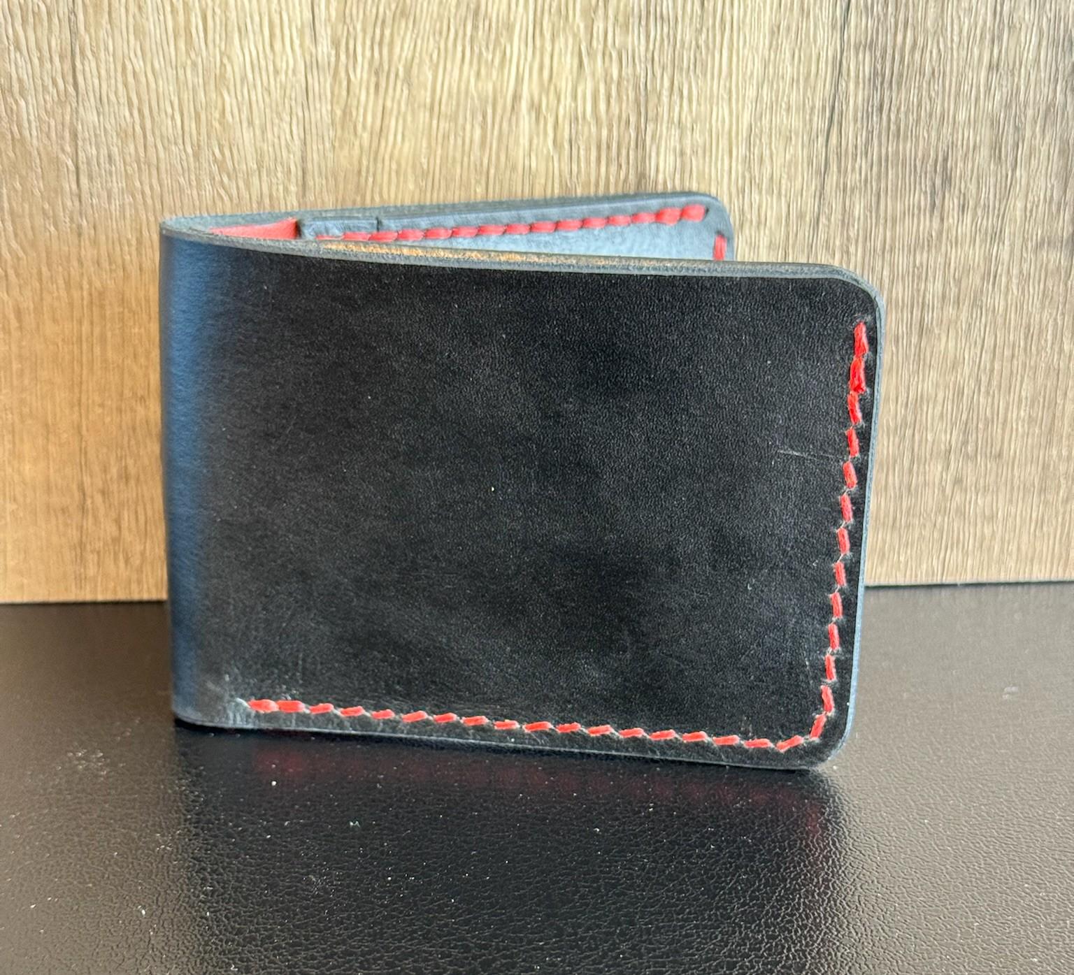 ハンドステッチの二つ折り財布。横型カードポケット。黒と赤のレザーに