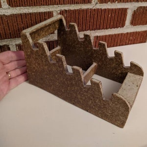 May include: A brown ceramic utensil holder with five slots. The holder is shaped like a staircase and has a speckled brown and white glaze.
