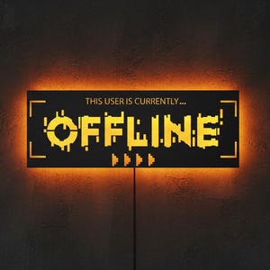 May include: A black rectangular sign with the text "THIS USER IS CURRENTLY...OFFLINE" in yellow, pixelated font. The sign is illuminated with an orange glow, and has a thin black wire extending from the bottom. The background is a dark, textured wall.