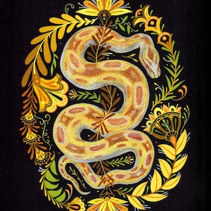 May include: A detailed illustration of a snake coiled within a floral oval frame. The snake is yellow and brown with red eyes. The floral frame features yellow, green, and brown leaves and flowers, set against a black background.