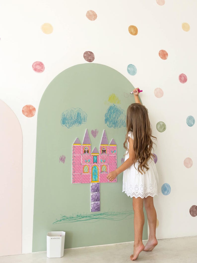 May include: A large sage green arch wall decal featuring a pink castle illustration with a stone path, surrounded by scattered watercolor-style polka dots. The castle has multiple towers, windows, and a central door, with hand-drawn blue clouds.