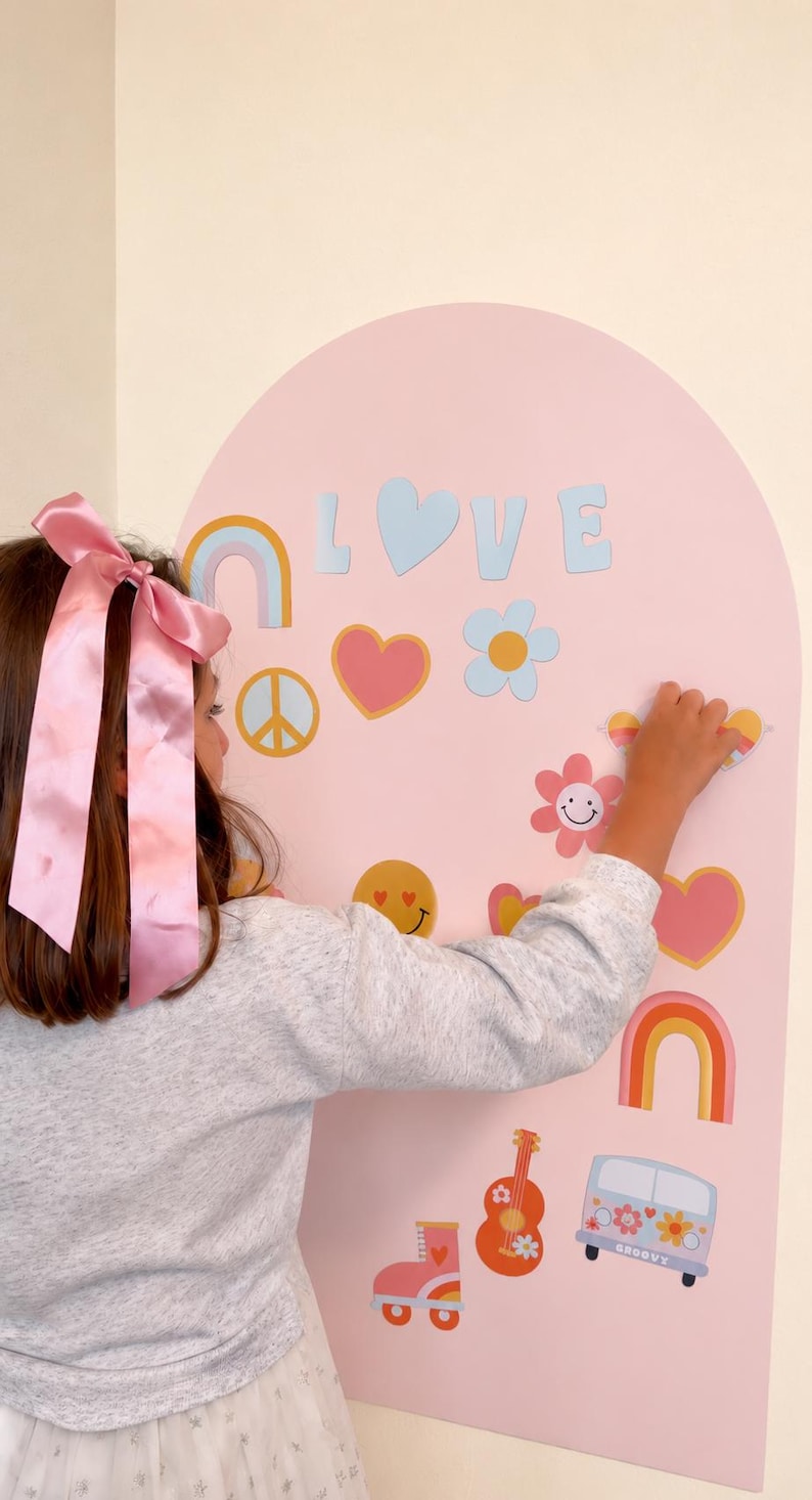May include: A light pink arched wall decal featuring the word LOVE and various colorful stickers including rainbows, hearts, flowers, a peace sign, a smiley face, a guitar, roller skates, and a van with the word GROOVY printed on the side.