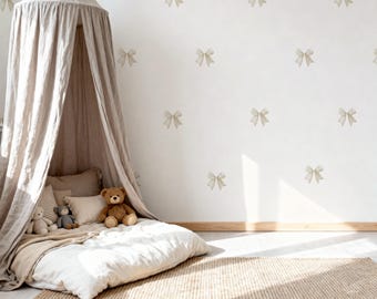May include: A neutral-toned nursery with a canopy bed, pillows, and stuffed animals. The white wall is decorated with bow-shaped decals. A woven rug covers the floor. The room is bathed in natural light, creating a cozy and inviting atmosphere.