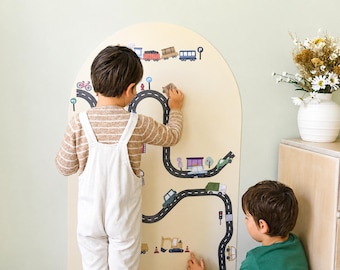 May include: A tall, arched, light-colored wooden wall panel featuring a printed black road map graphic with various vehicles, traffic signs, and buildings. The design includes a train at the top and construction equipment at the bottom.