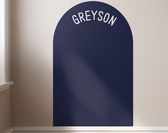 May include: A dark navy blue arch-shaped wall decal featuring the name GREYSON printed in white capital letters along the top curve. The decal has a smooth, solid matte finish and is applied to a plain, light-colored interior wall surface.