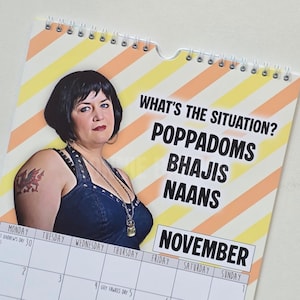 May include: A wall calendar with a spiral binding, featuring a woman and the text "WHAT'S THE SITUATION? POPPADOMS BHAJIS NAANS" and "NOVEMBER". The background has diagonal yellow and orange stripes.