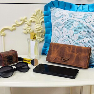 Stylish wallet with hand strap holds your phone credit cards and more with multiple compartments for smart and easy daily organization.