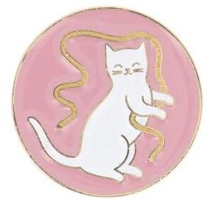 Könnte beinhalten: Eine kreisförmige Emaille-Anstecknadel mit einer weißen Katze auf hellrosa Hintergrund. Die Katze ist stehend dargestellt und spielt mit einem langen, gewundenen goldfarbenen Band, das sich um ihren Körper schlängelt. Die Nadel hat einen dünnen Goldrand.