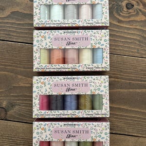 Puede incluir: Cuatro cajas de carretes de hilo Susan Smith Efina. Cada caja tiene un diseño floral y contiene cinco carretes de hilo 100% algodón egipcio de fibra extra larga. Los colores del hilo varían, incluyendo pasteles y tonos joya.
