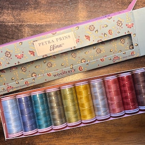 May include: A set of ten spools of Petra Prins Efina 60wt 100% extra long staple Egyptian cotton thread in a rectangular box. The box features a floral pattern and contains spools in shades of blue, green, yellow, grey, pink, red, and brown.